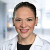 Carolina Solis-Herrera smiling in a headshot.